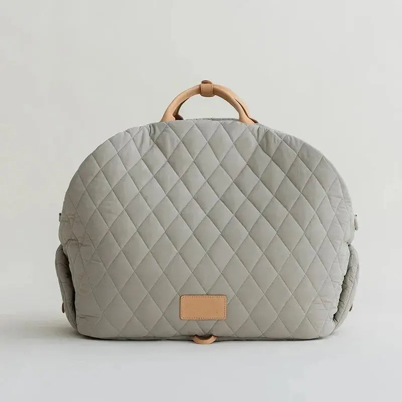 Sac à dos matelassé gris avec poignée en bois comme sac de transport et lit de voyage pour chiots et petits chiens
